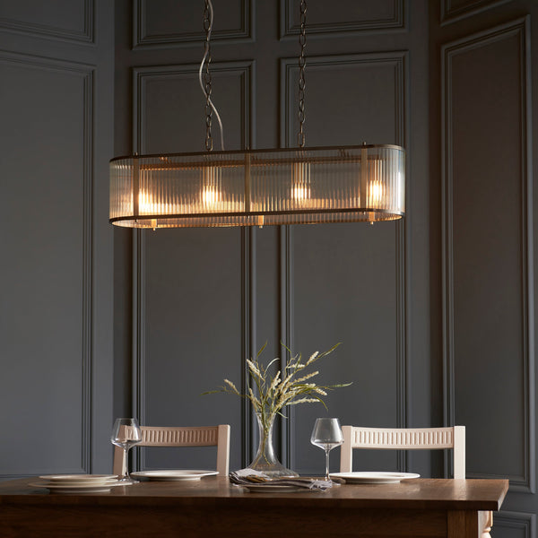 Endon Ridgeton 4-Light Linear Pendant in Antique Brass & Ribbed Glass features a classic design, height-adjustable chain, and clear ribbed glass panels for a sophisticated lighting effect. Dimmable and LED-compatible, this elegant fixture is perfect for dining rooms, kitchen islands, and stylish interiors.