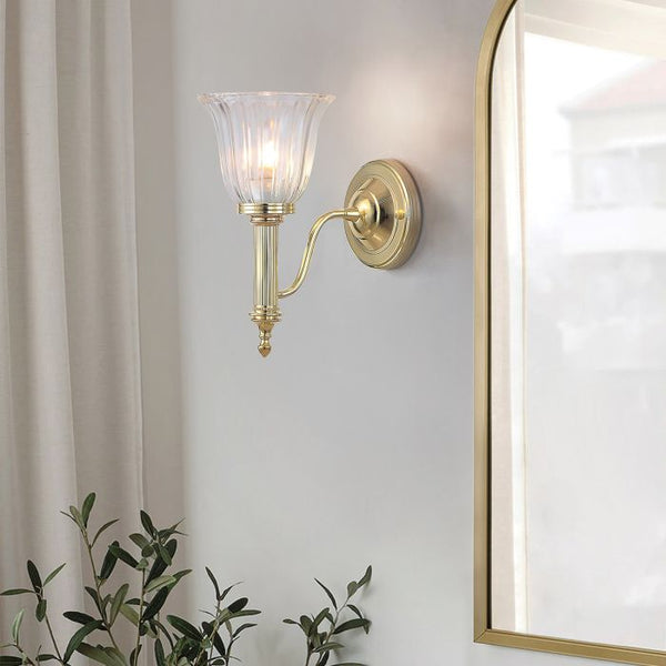 Elstead Carroll 1 Light Wall Light in polished brass with a solid brass body and elegant finish. IP44-rated for bathroom use, includes a 3W LED G9 bulb. Provides warm 3000K illumination with a stylish design.