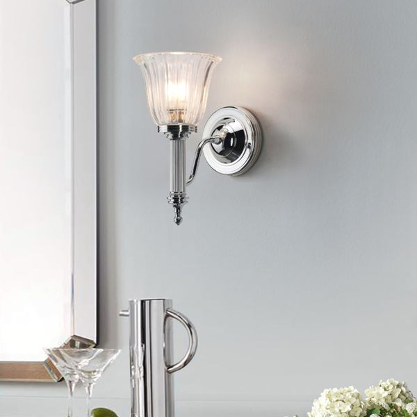 Elstead Carroll 1 Light Wall Light in polished chrome with a solid brass build and sleek finish. IP44-rated for bathroom use, includes a 3W LED G9 bulb. Provides warm 3000K illumination with a stylish design.