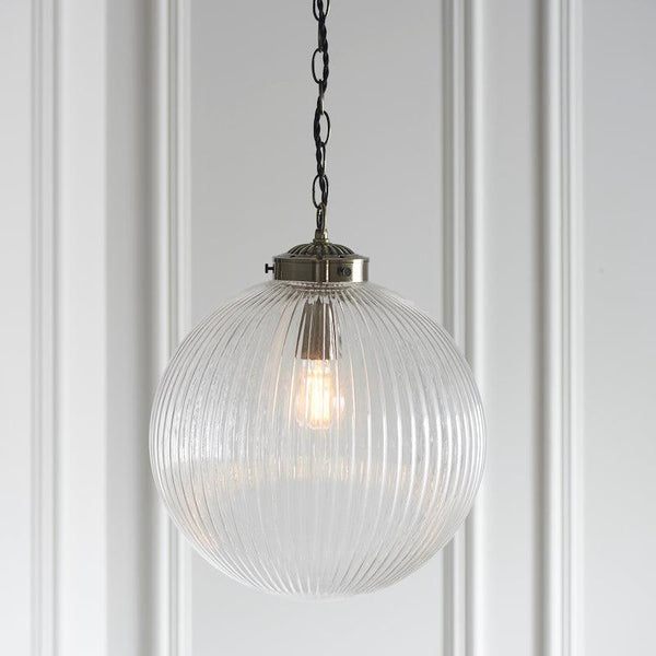 Endon Brydon 1 Light Pendant features a clear ribbed glass shade with an antique brass finish. This adjustable pendant light is perfect for energy-efficient lighting, offering a timeless design for spaces like kitchens, hallways, or living rooms.