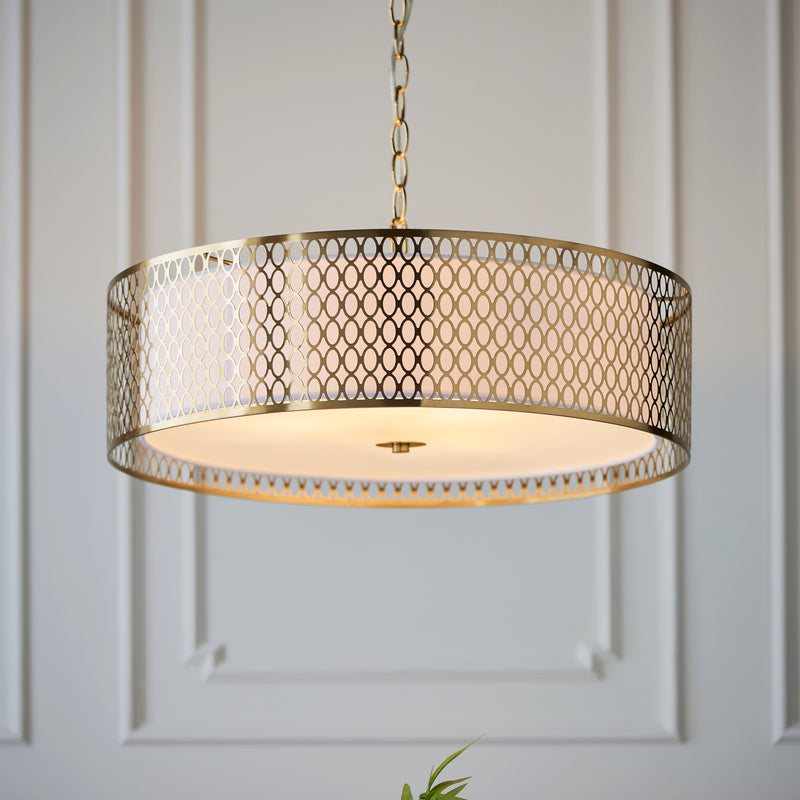 Cordero 3 Light Pendant in gold fretwork hanging in a living room