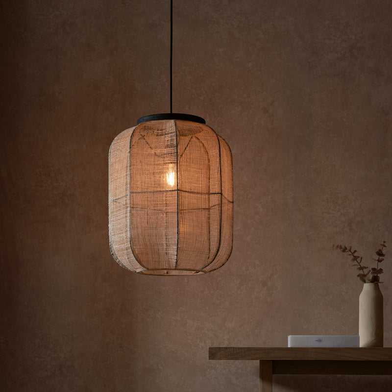 Zaire Medium Pendant in natural linen and dark plywood shown in a room setting