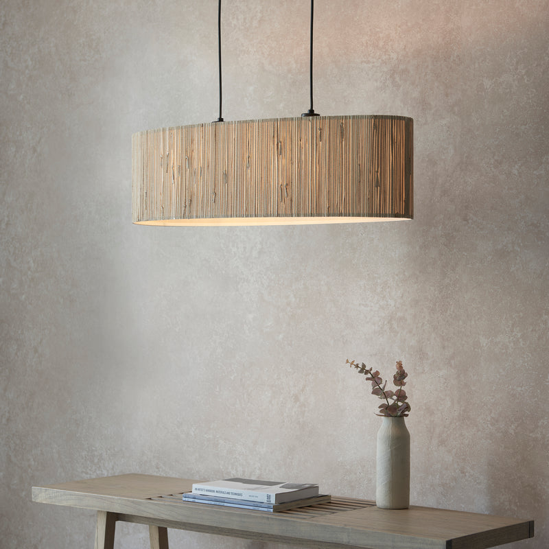 Longshore 2 Light Linear Pendant in natural seagrass and matt black hanging in a dining room