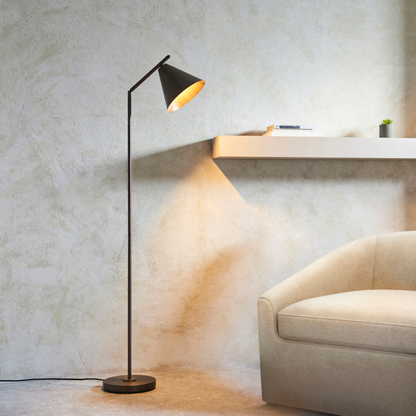 Cape Task Floor Lamp lit up in a living room setting