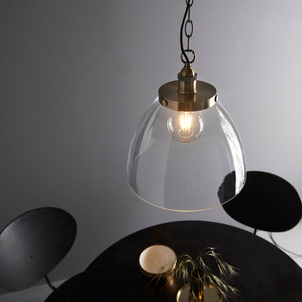 Hansen Grand Pendant in antique brass shown in a room setting