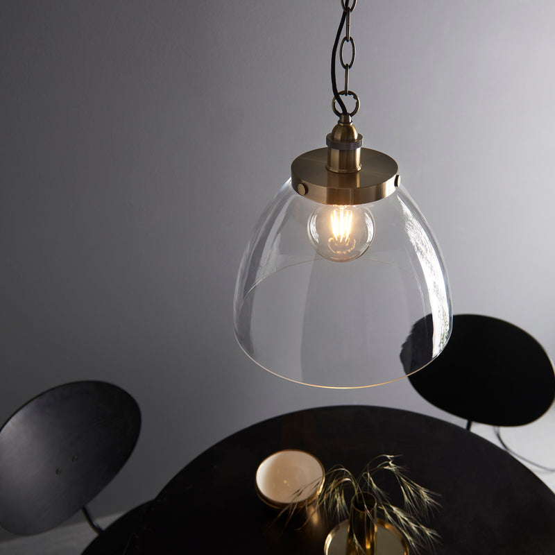 Hansen Grand Pendant in antique brass shown in a room setting