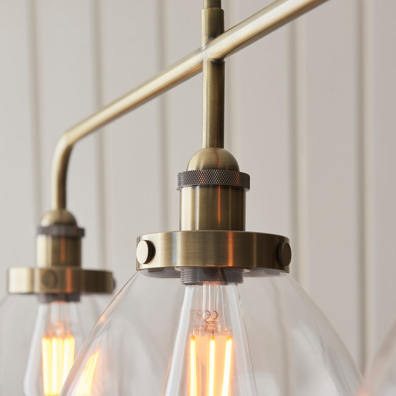 Detail of the antique brass finish on the Hansen 3 Light Linear Bar Pendant