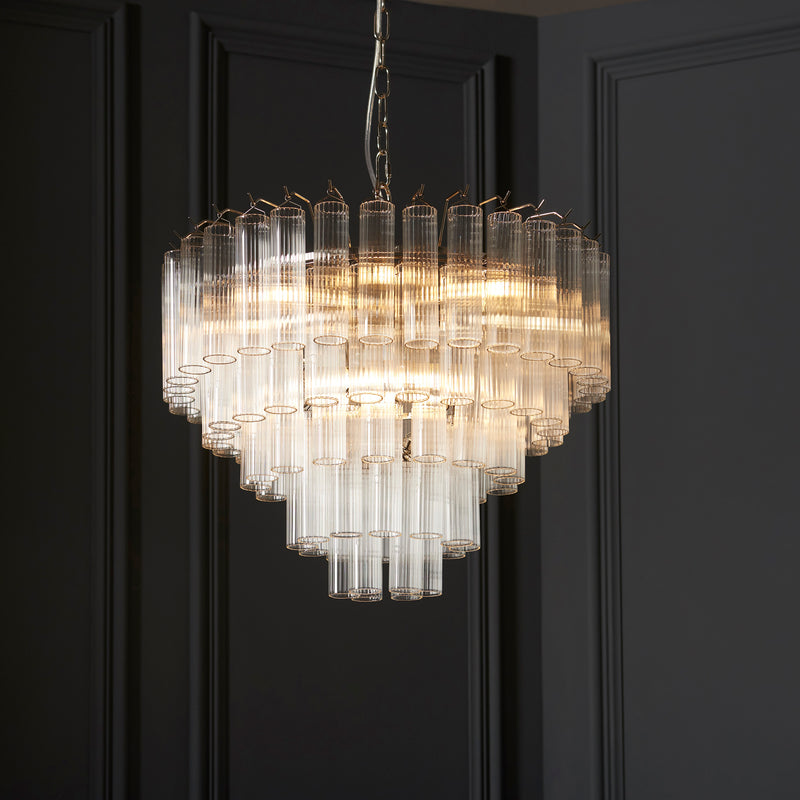 Toulouse 12 Light Tiered Chandelier in bright nickel hanging in a living room