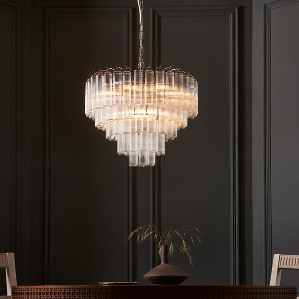 Toulouse 12 Light Tiered Chandelier lit up in a styled living room