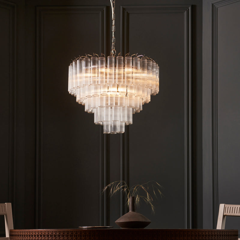 Toulouse 12 Light Tiered Chandelier lit up in a styled living room