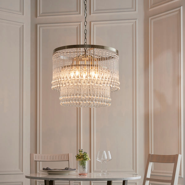 Genevieve 5 Light Chandelier in antique brass hanging in a dining room