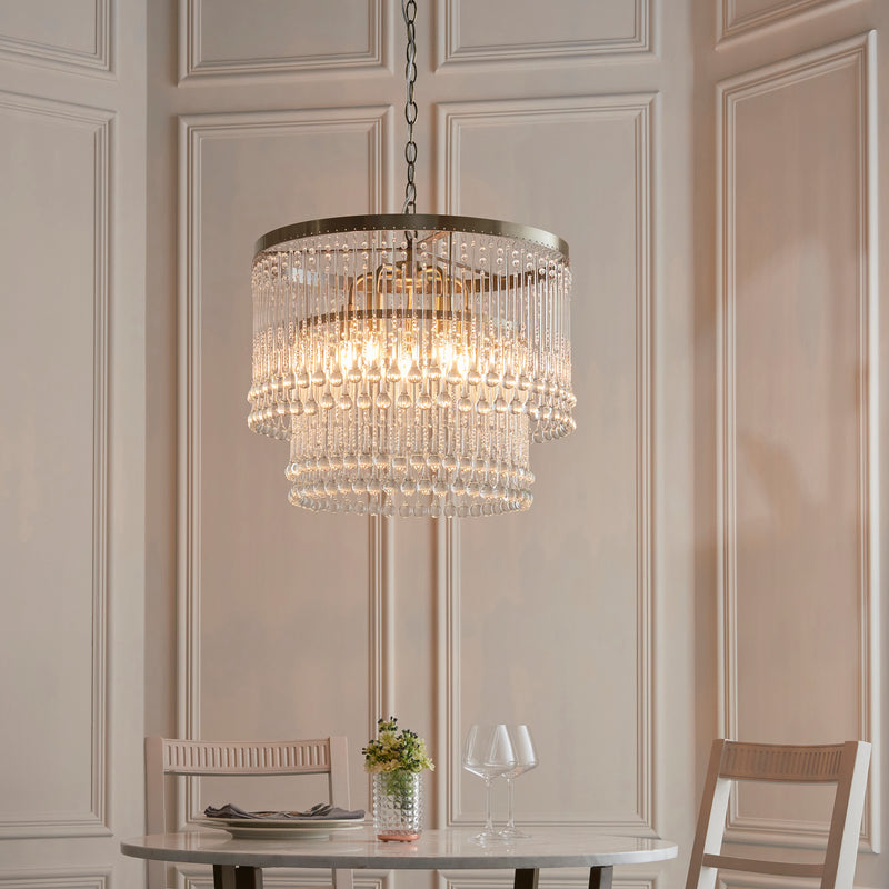 Genevieve 5 Light Chandelier in antique brass hanging in a dining room