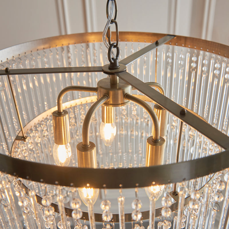 Genevieve 5 Light Chandelier in antique brass shown in a room setting