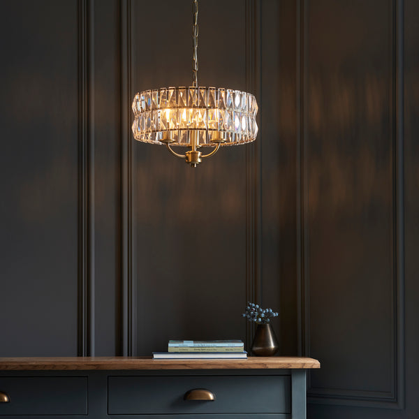 Clifton 3 Light Pendant lit up in a styled bedroom
