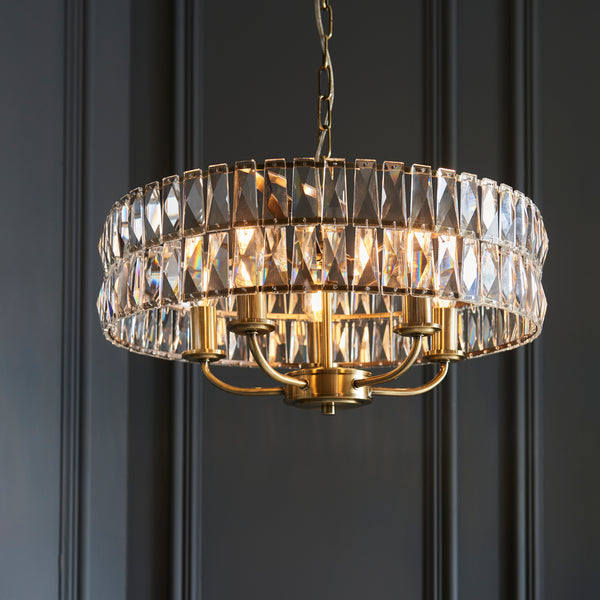Clifton 5 Light Pendant in antique brass hanging in a living room