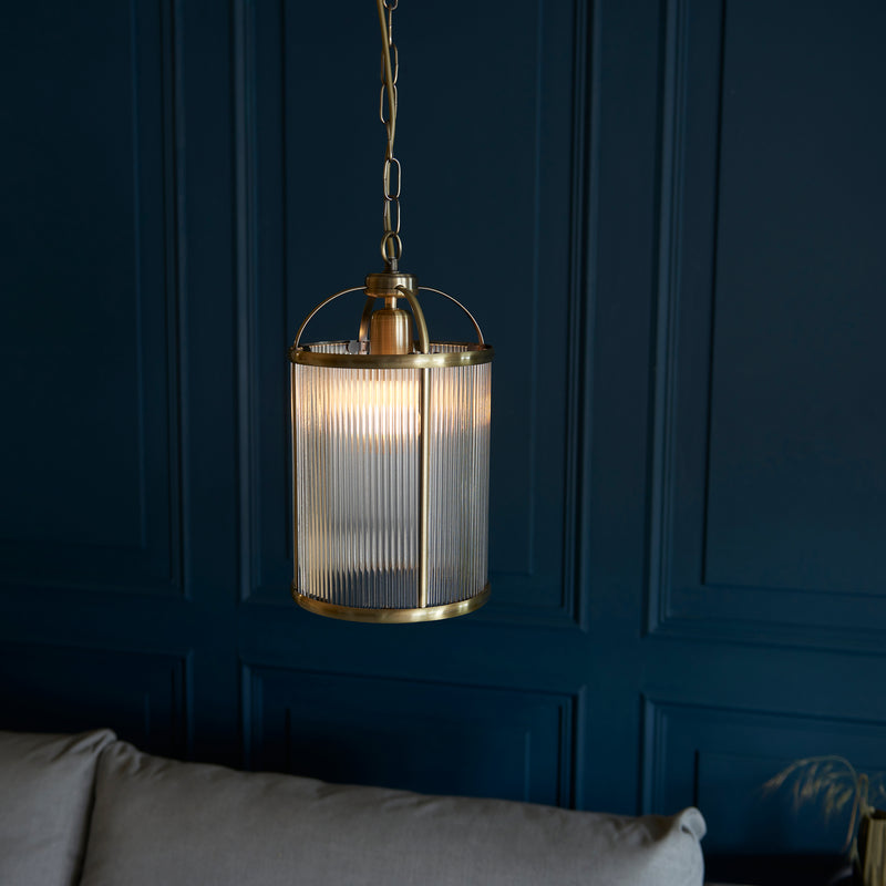 Lambeth Ribbed Lantern Pendant in antique brass hanging in a hallway