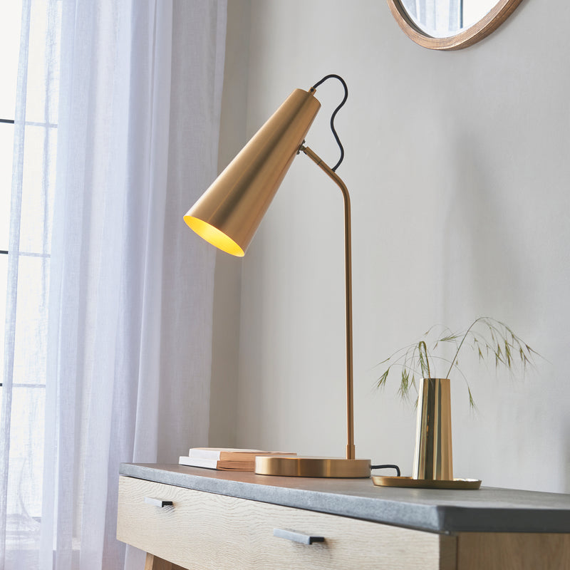 Karna Task Table Lamp lit up in a bedroom setting