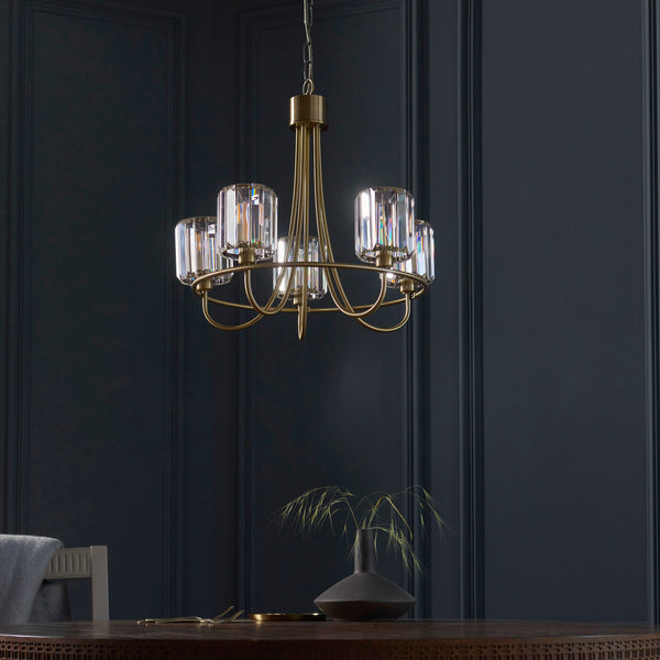 Berenice 5 Light Chandelier in antique brass hanging in a living room