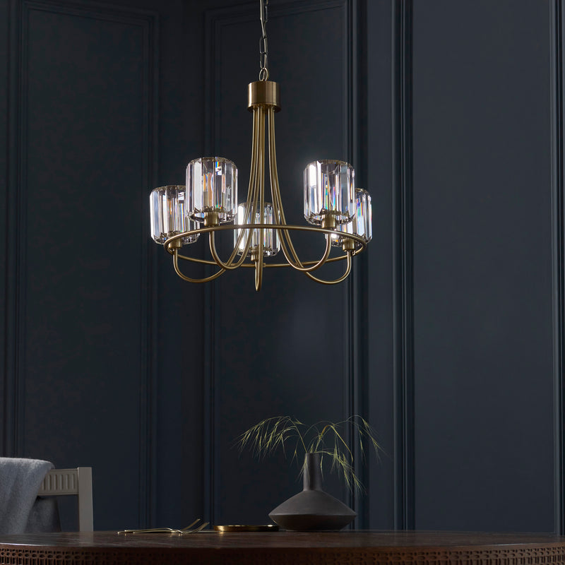 Berenice 5 Light Chandelier in antique brass hanging in a living room