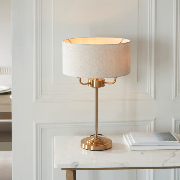 Highclere 3 Light Table Lamp lit up in a living room setting