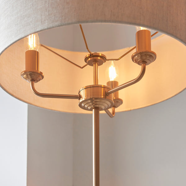 Highclere 3 Light Floor Lamp lit up in a living room setting
