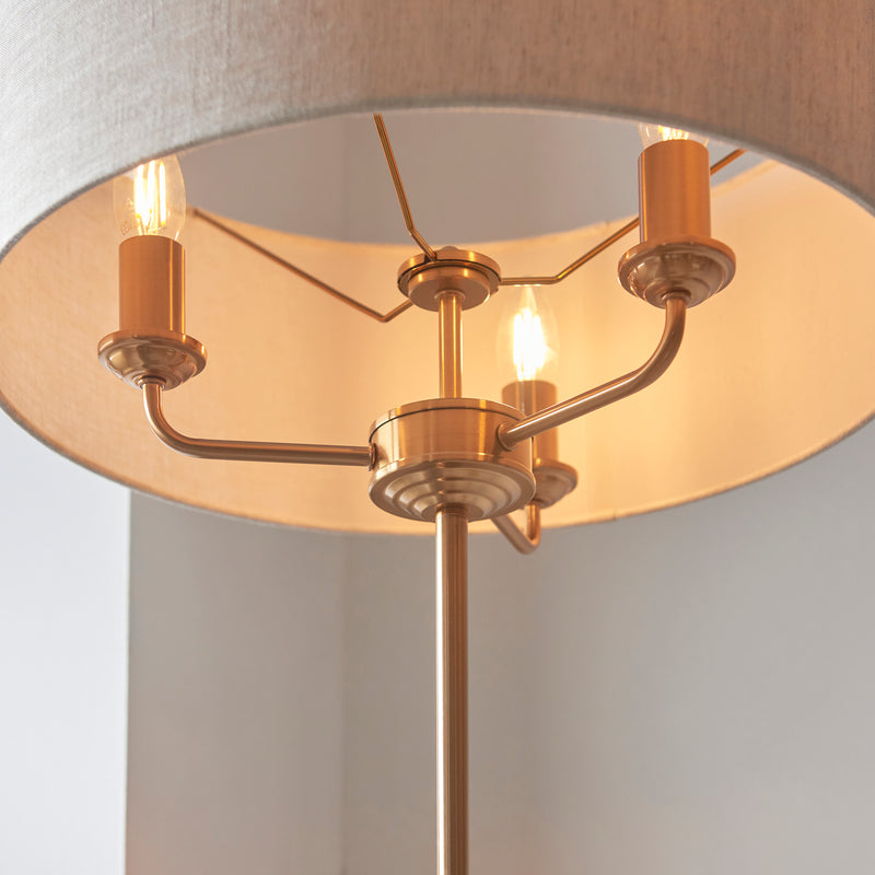 Highclere 3 Light Floor Lamp lit up in a living room setting