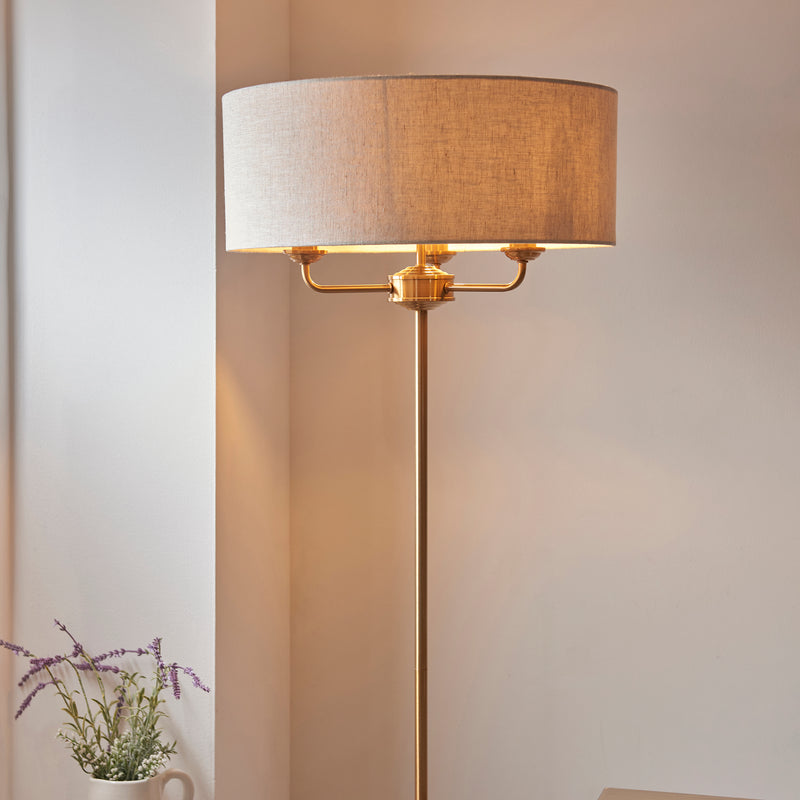 Highclere 3 Light Floor Lamp lit up in a living room setting