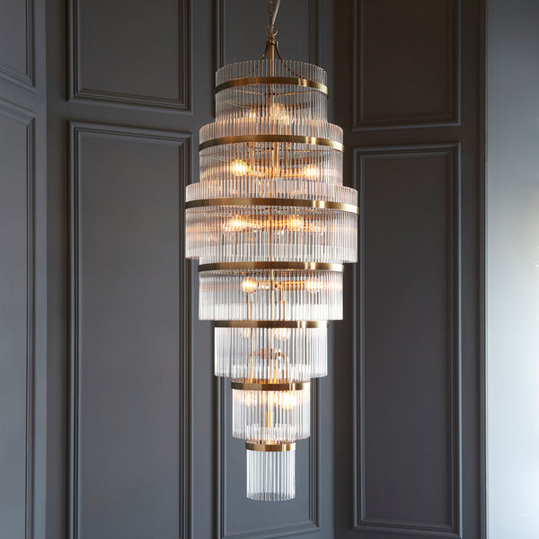 Marietta Grand 21 Light Tiered Chandelier in antique brass hanging in a stairwell