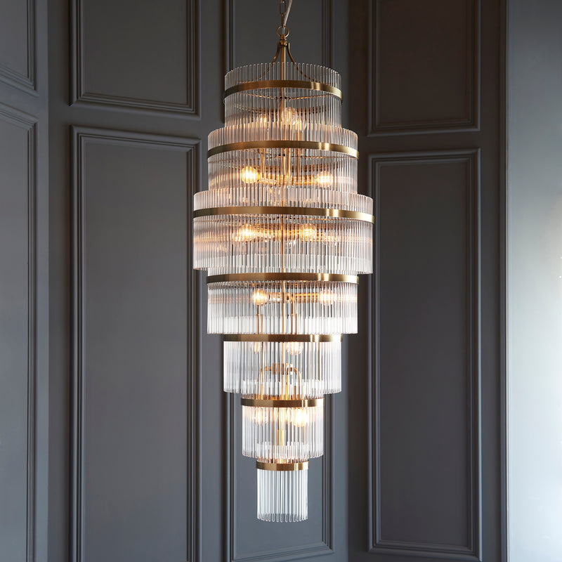 Marietta Grand 21 Light Tiered Chandelier in antique brass hanging in a stairwell