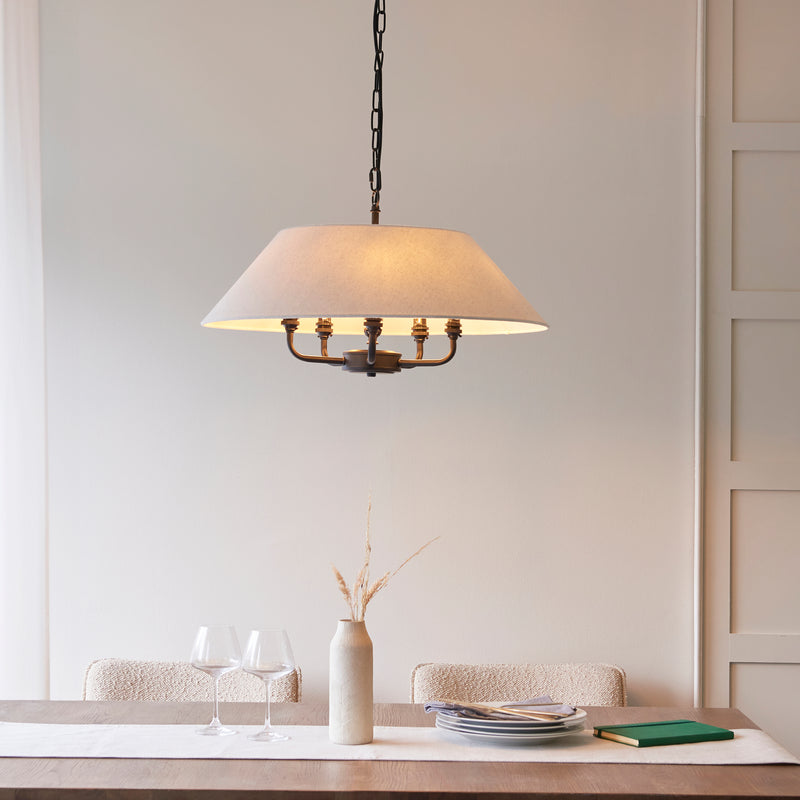 Lille 5 Light Pendant in matt black and natural linen hanging in a living room