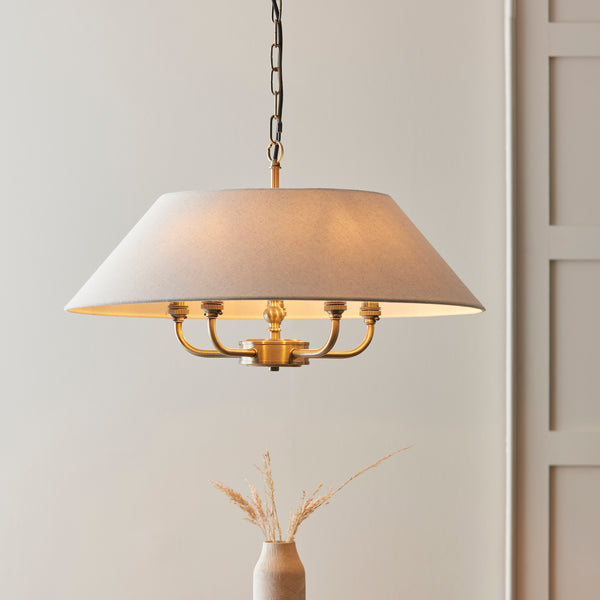 Lille 5 Light Pendant in antique brass and natural linen shown in a room setting