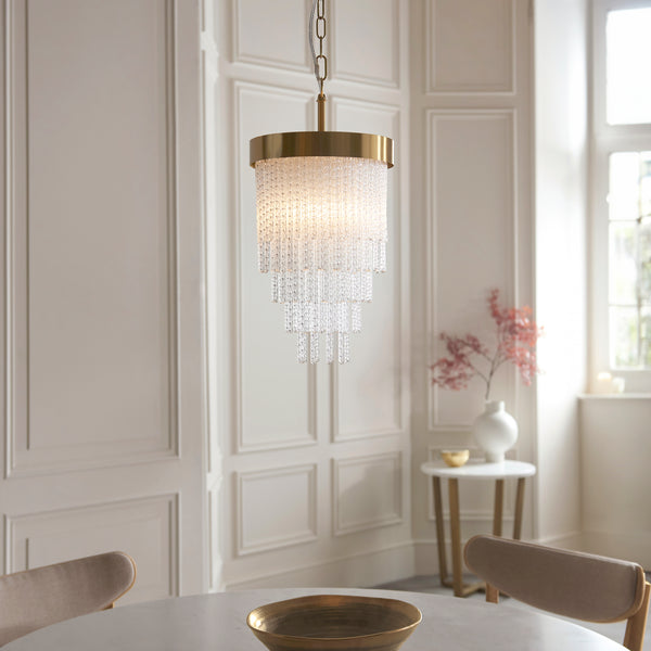 Anistoria Pendant in brushed aged brass hanging in a hallway