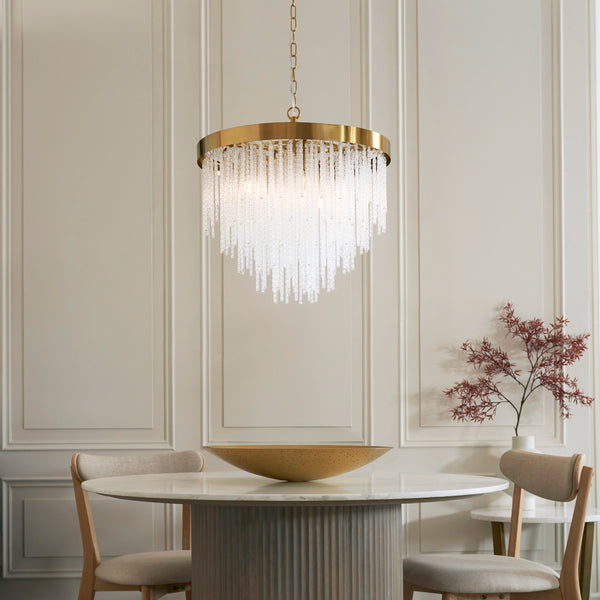 Anistoria 5 Light Chandelier in brushed aged brass hanging in a dining room