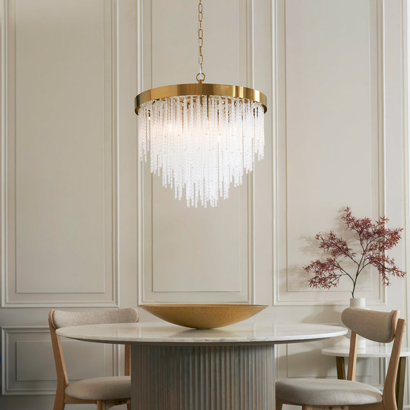 Anistoria 5 Light Chandelier in brushed aged brass hanging in a dining room