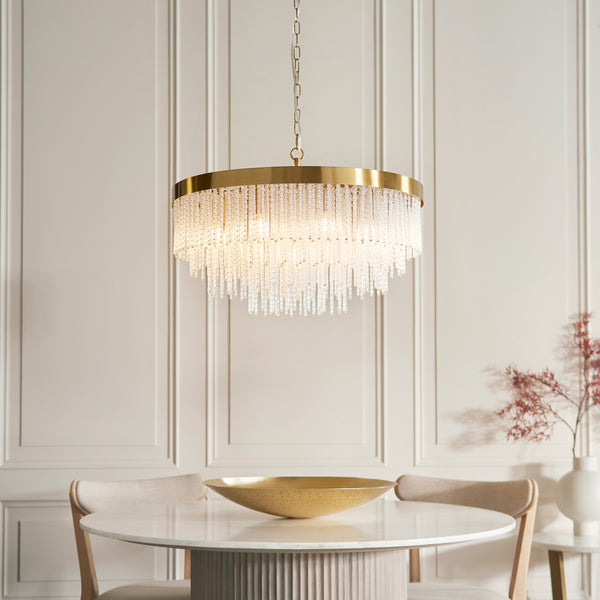 Anistoria Grand 9 Light Chandelier in brushed aged brass hanging in a living room