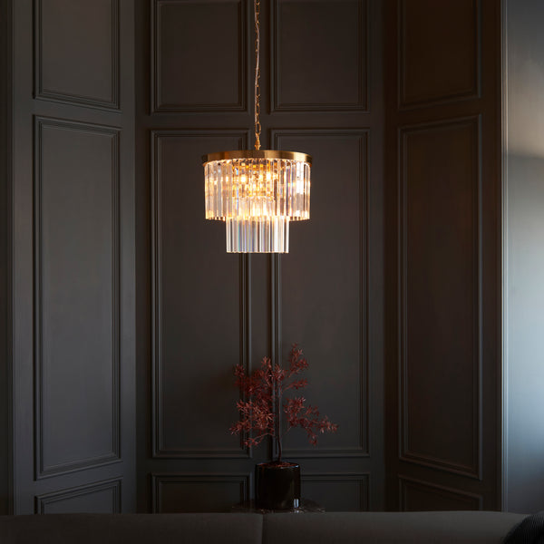 Conaston 4 Light Chandelier in brushed aged brass hanging in a dining room