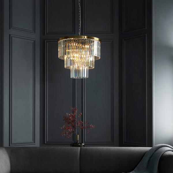 Conaston 7 Light Chandelier in brushed aged brass hanging in a living room