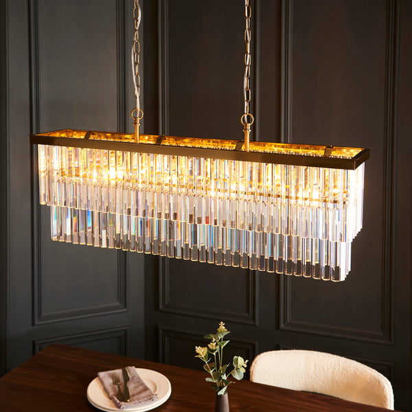 Conaston 4 Light Linear Chandelier lit up in a styled dining room