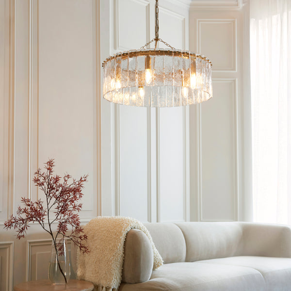 Karine 5 Light Pendant in brushed aged brass hanging in a dining room