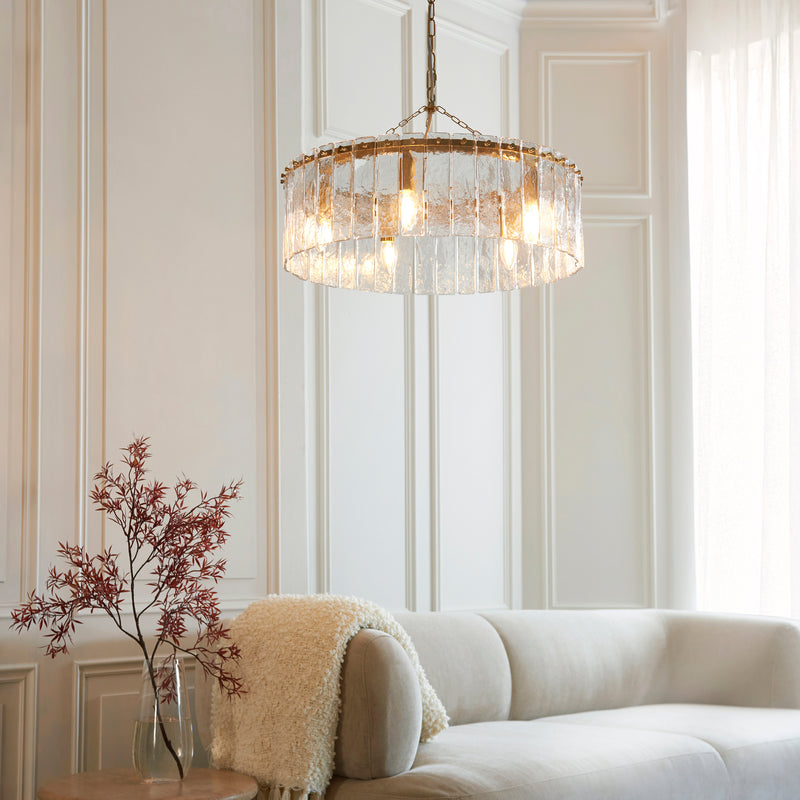 Karine 5 Light Pendant in brushed aged brass hanging in a dining room