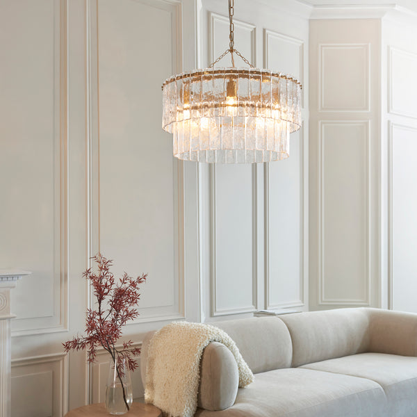 Karine 5 Light Tiered Pendant in brushed aged brass hanging in a living room