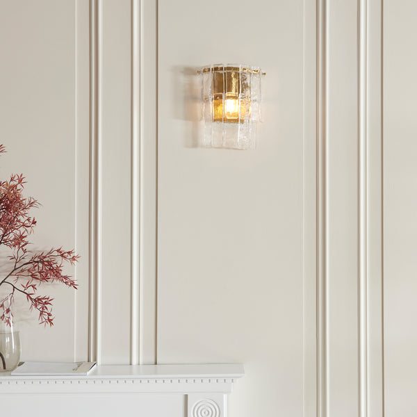 Karine Wall Light in brushed aged brass on a wall