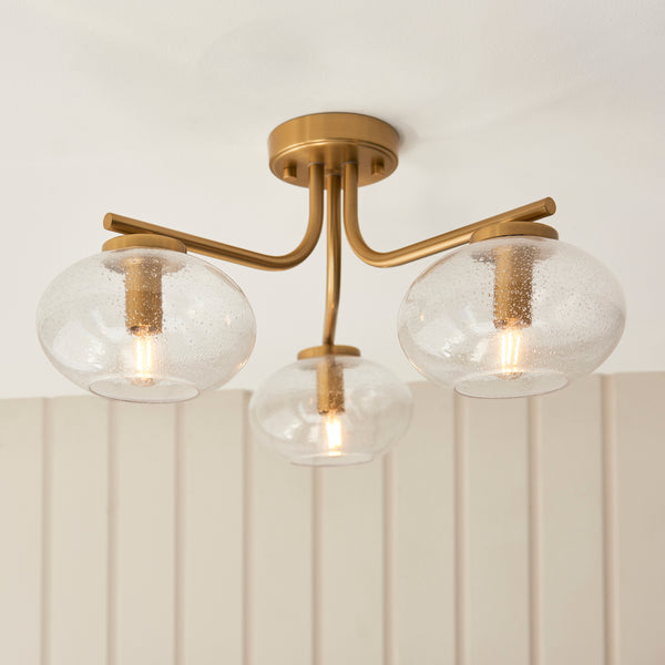 Jacob 3 Light Semi Flush Ceiling Light lit up in a styled bedroom