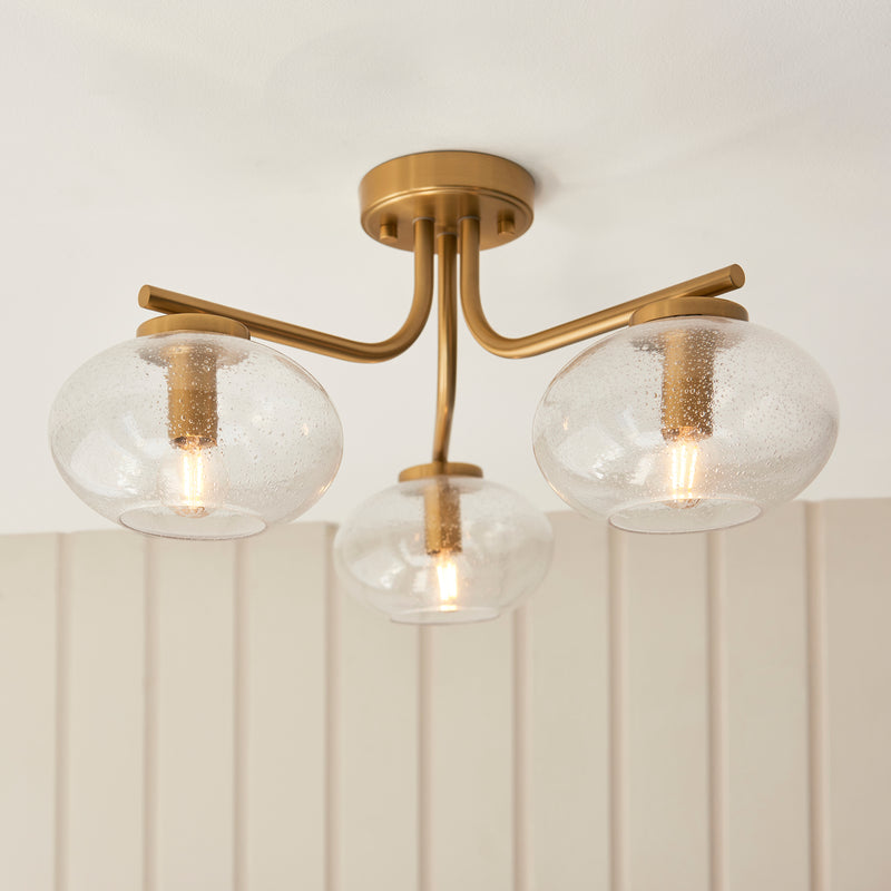 Jacob 3 Light Semi Flush Ceiling Light lit up in a styled bedroom