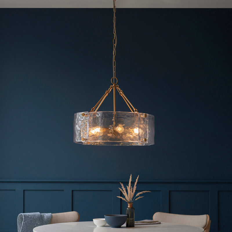 Keller 6 Light Pendant in brushed aged brass hanging in a dining room