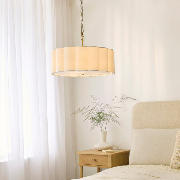 Serene 3 Light Pendant in brushed aged brass hanging in a bedroom