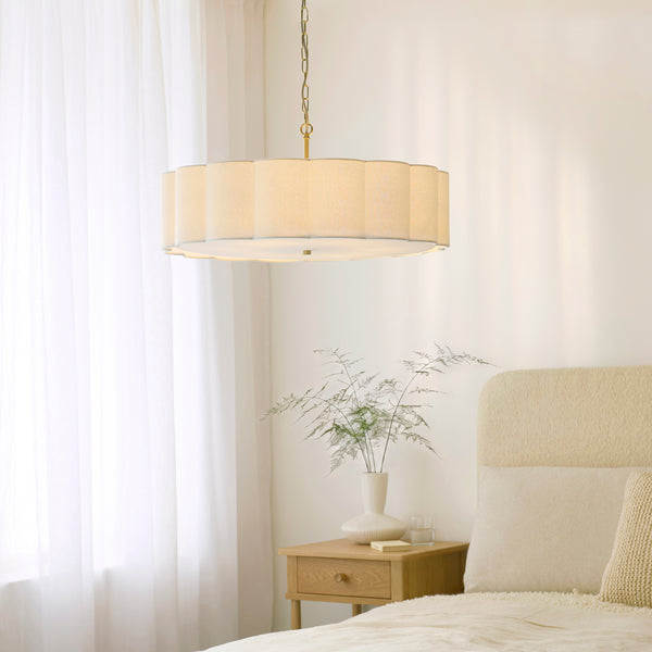 Serene 6 Light Pendant in brushed aged brass hanging in a living room