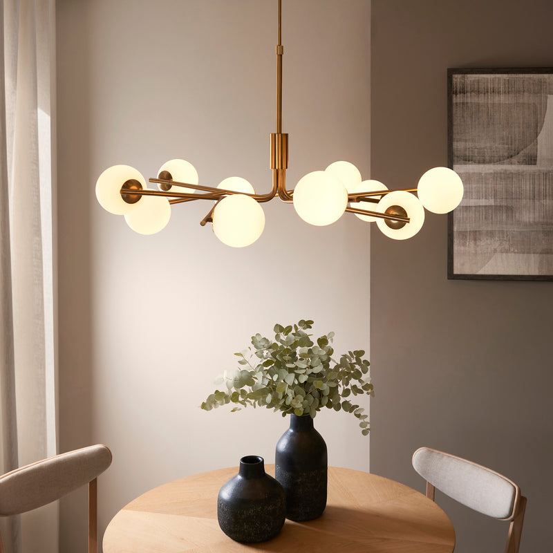 Aaron 10 Light Globe Pendant in brushed aged brass shown in a room setting