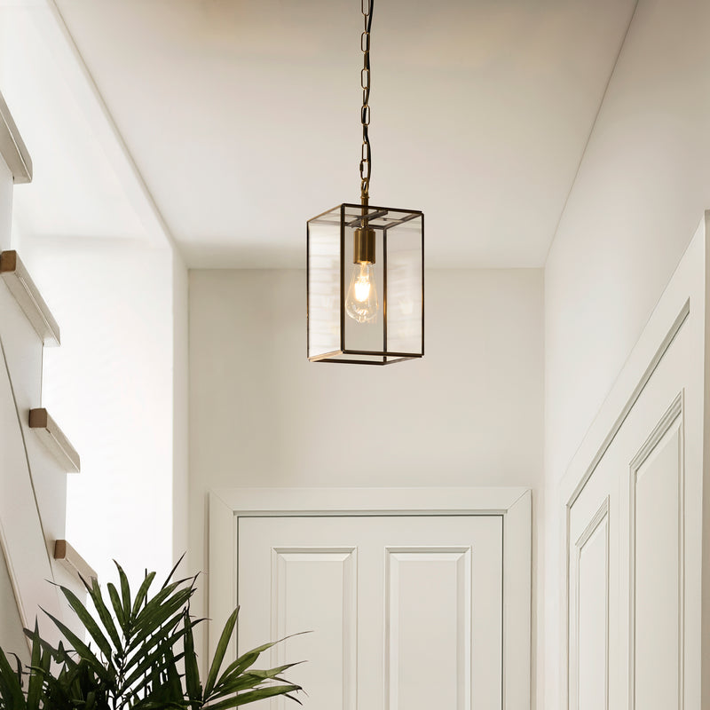 Hammond Lantern Pendant in aged brass hanging in a hallway