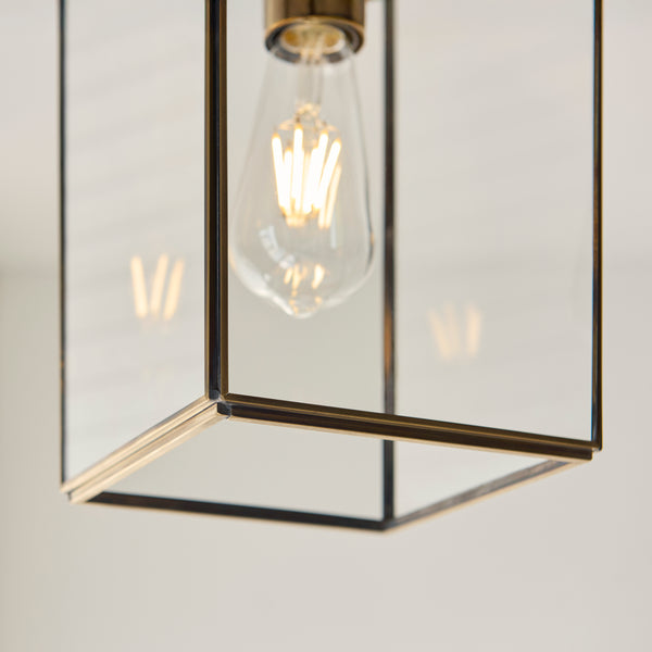 Hammond Lantern Pendant in aged brass shown in a room setting